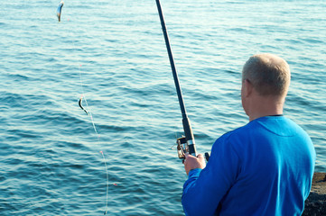Fishing on a Salak. A man caught a fish on a fishing rod. Fishing in the evening. Sea fishing in...