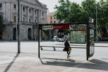 girl alone waiting for the bus in a big city