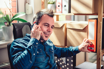 Businessman sitting at the desk talking on the phone and reaching for ring board