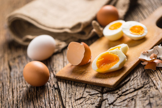 Close-up boiled or raw chicken eggs on wooden board