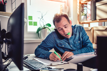 Men talking on the phone and highlighting text in document folder