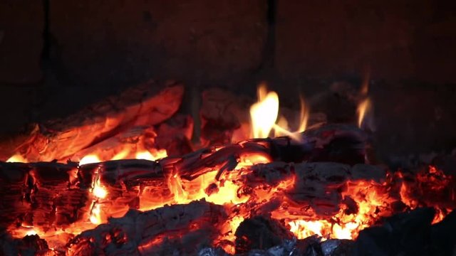 Firewood and fire flames in fireplace, bonfire close-up, 4K UHD.

