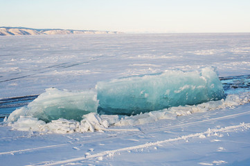 Winter landscape, Crystal clear ice chunks, icicles,Lake Baikal, Siberia, Russia. Sunny winter day weather, ice cracks, clear water, slippy and cold frozen ground.