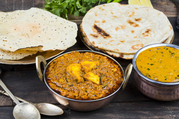 Indian Food Kadai Paneer Served With Dal Makhani, Tandoori or Papad Also Called Kadhai Paneer or Karahi Paneer is an Indian Dish of Marinated Paneer Cheese Served in Spiced Gravy on Wooden Background