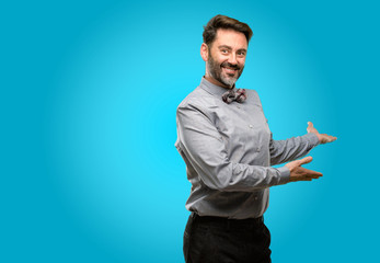 Middle age man, with beard and bow tie confident and happy with a big natural smile inviting to enter