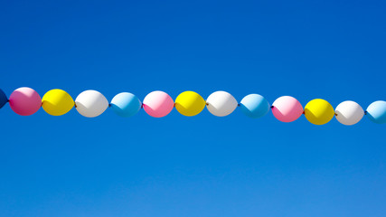 Multicolored festive balloons against the blue sky