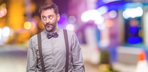 Middle age man, with beard and bow tie doubt expression, confuse and wonder concept, uncertain...