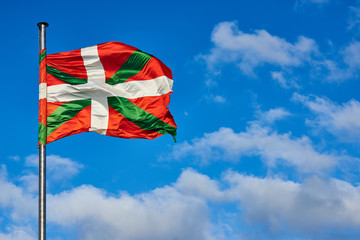 Ikurrina, Basque Country flag waving on a blue sky.