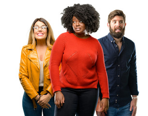 Group of three young men and women confident and happy with a big natural smile laughing