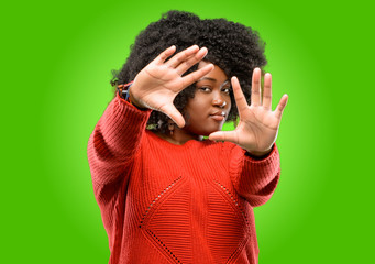 Beautiful african woman confident and happy showing hands to camera, composing and framing gesture