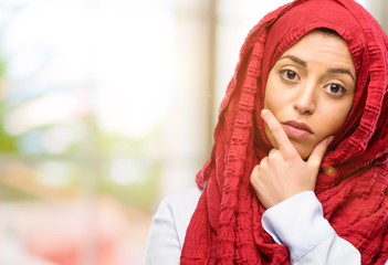 Young arab woman wearing hijab doubt expression, confuse and wonder concept, uncertain future