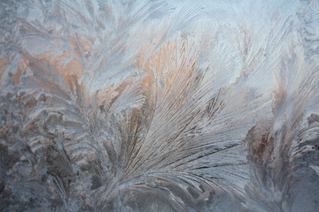 Frosty drawing on glass in the form of feathers