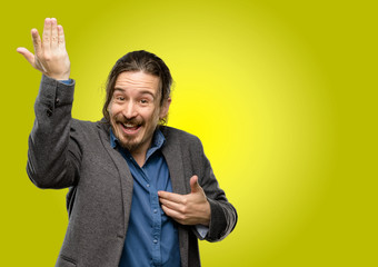 Handsome young man happy and surprised cheering expressing wow gesture pointing up