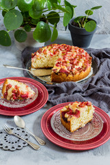 Easy rhubarb cake. Grey background, red plates and green pilea/plant.