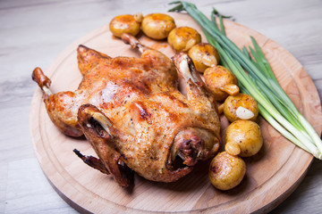 Duck baked whole, with potatoes and garlic. Selective focus, close-up.