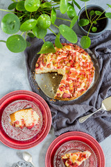 Easy rhubarb cake. Grey background, red plates and green pilea/plant.