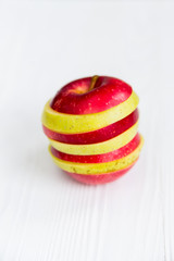 Mixed slices of red and green apple on white close