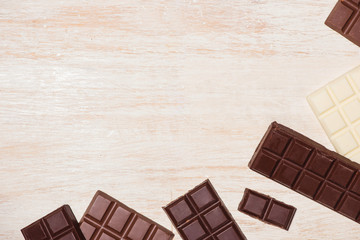 A lot of variety chocolates bar in box on white wooden background