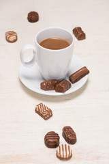 Glass of chocolate milk and variety chocolates  on table