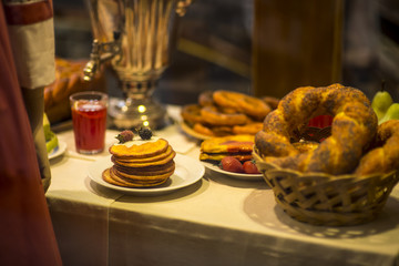 Pancakes filled with old russian service and samovar for breakfast. Rolled pancakes