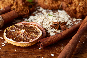 Christmas composition with oatmeal, chocolate biscuits, and spices, on wooden background, close-up, selective focus.