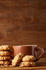 Porcelain cup of tea and sweet cookies on wooden background, top view, selective focus