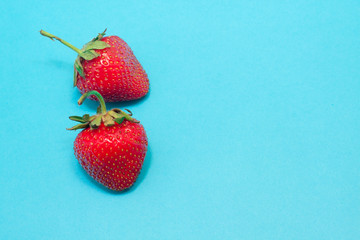 Freshly picked strawberries isolated on a blue background.