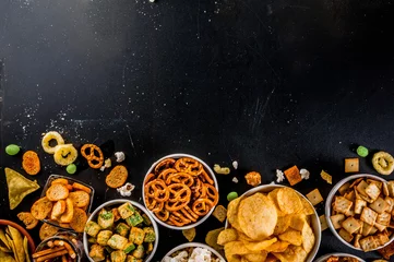 Fotobehang Variation different unhealthy snacks crackers, sweet salted popcorn, tortillas, nuts, straws, bretsels, back chalkboard copy space © ricka_kinamoto