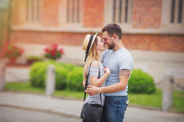 Young couple, brunet man and blonde girl, in the european city old town. Summertime season