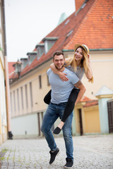 Young couple, brunet man and blonde girl, in the european city old town. Summertime season