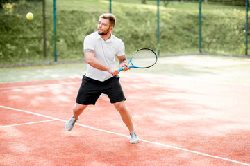 Young couple in white sports wear playing tennis on the tennis court outdoors