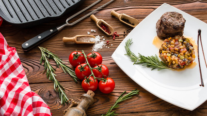 Steak chateaubriand, ratatouille, cherry tomatoes, rosemary, pepper beans, sea salt, grill pan on wooden background, top view - 205387519