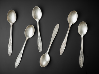 old silver spoons on black background