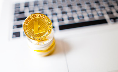 Litecoin and pile of coins on laptop computer, cryptocurrency concept