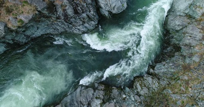 Mountain river flowing in a canyon in springtime, bird view, perspective from above.