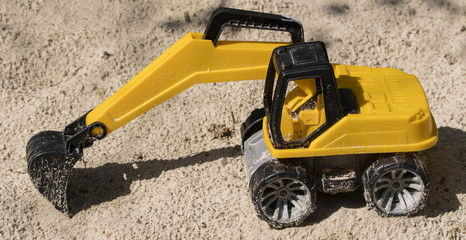 A small and sand-drenched excavator.