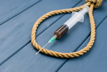 Drugs are suicide. A syringe in a loop for the gallows.