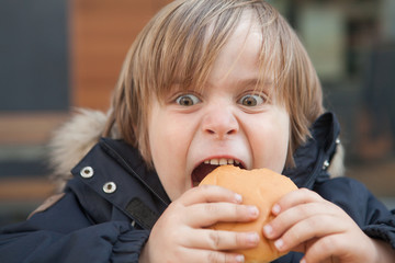 Little boy eating a hamburger