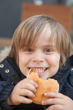 Little boy eating a hamburger