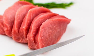 Pork fillets slice into pieces on a white background.