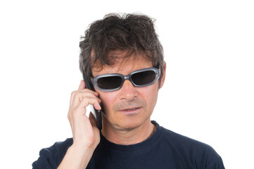 Adult man in sunglasses talking by smartphone on white background