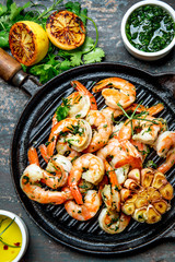 Grilled shrimps prawns on vintage grill pan, top view. Dark background