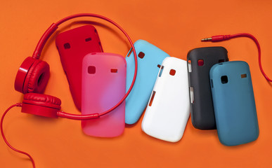 bright headphones and covers for the phone on an orange background