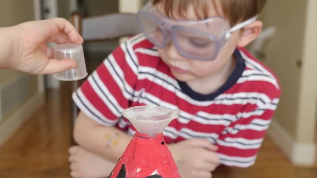A cute little boy prepares to do the volcano science experiment