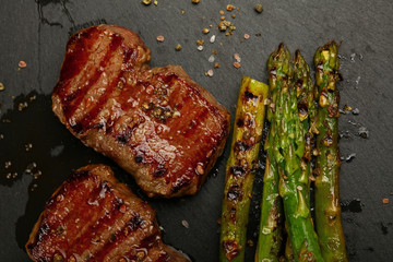 Close up grilled beef steaks on black slate board