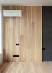 Air condition in modern designed room with natural wooden panels and black electric switch