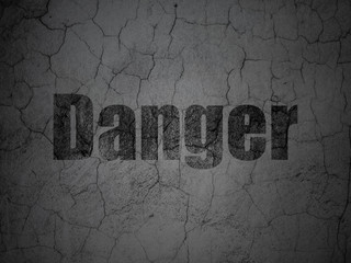 Protection concept: Black Danger on grunge textured concrete wall background