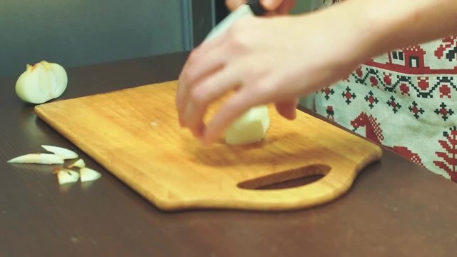 Female hands cut vegetables on a wooden cutting board