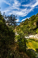 A Mountain River With Crystal Clear Waters Under A Bridge In Corsica