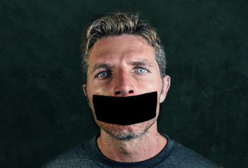 young man with mouth and lips sealed covered with adhesive tape in censorship coerced freedom of...